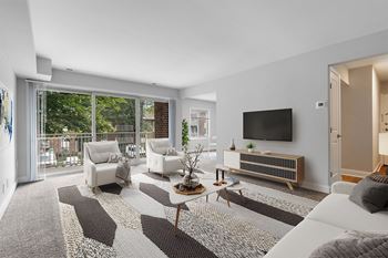 A living room with white furniture and a flat screen tv on the wall